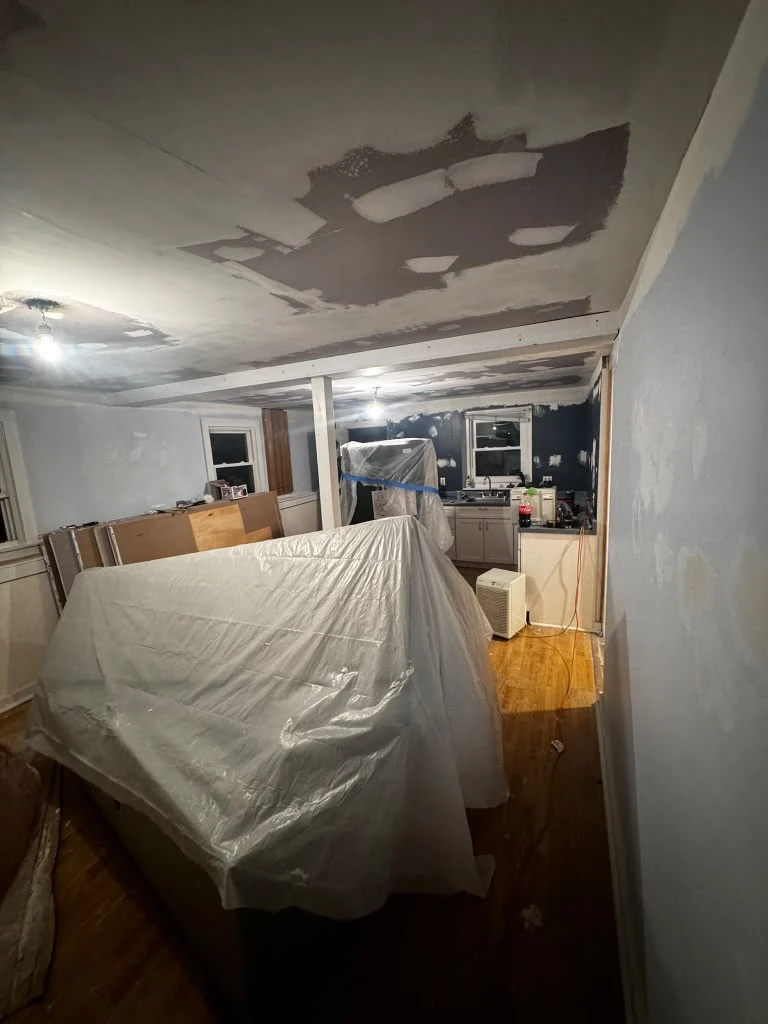SHC interior renovation in progress, with patched walls and ceiling, protected furniture and hardwood floors